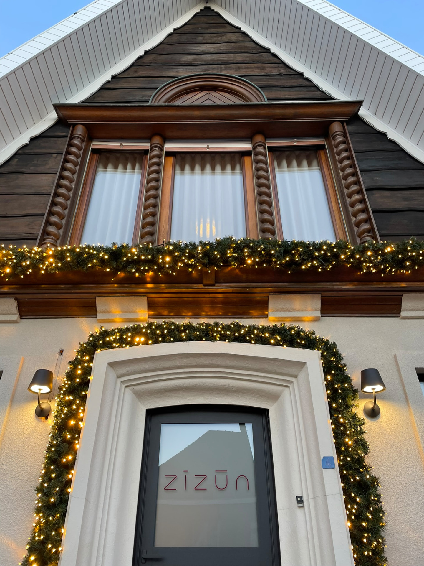 Verlichte guirlandes rond een woningentree en bovenramen