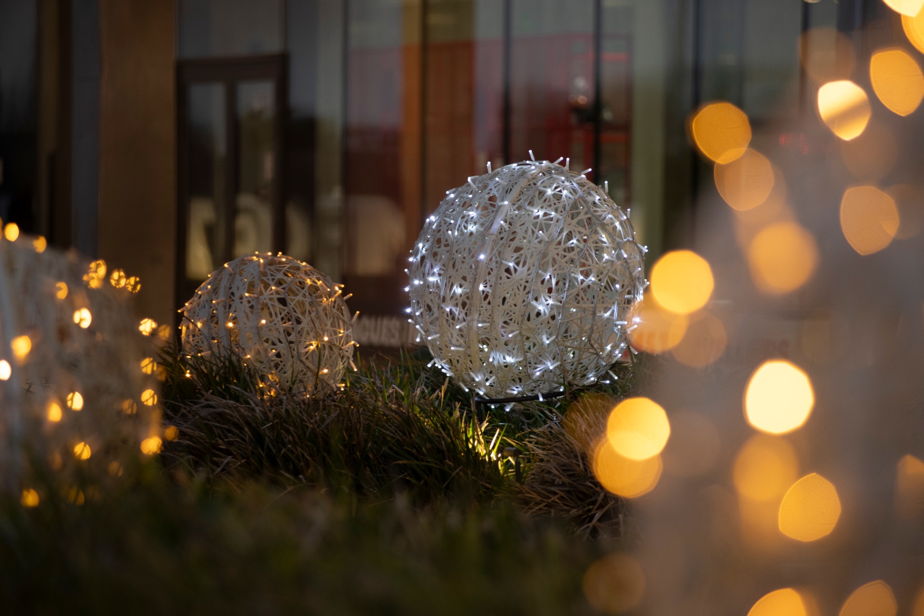 Detail van kerstballen genesteld in het gras met bokeh