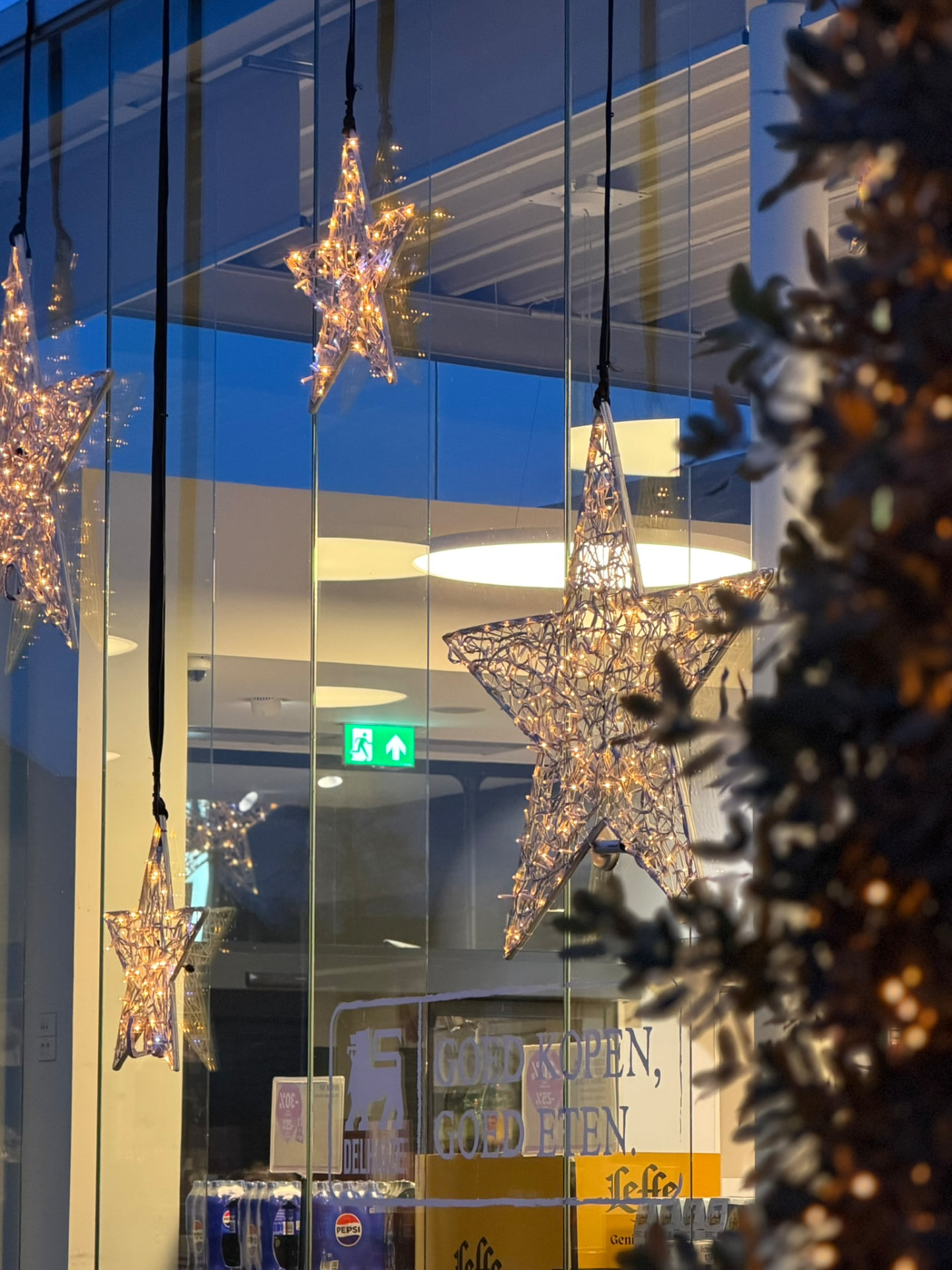 Hangende kerststerren voor een glazen winkelgevel