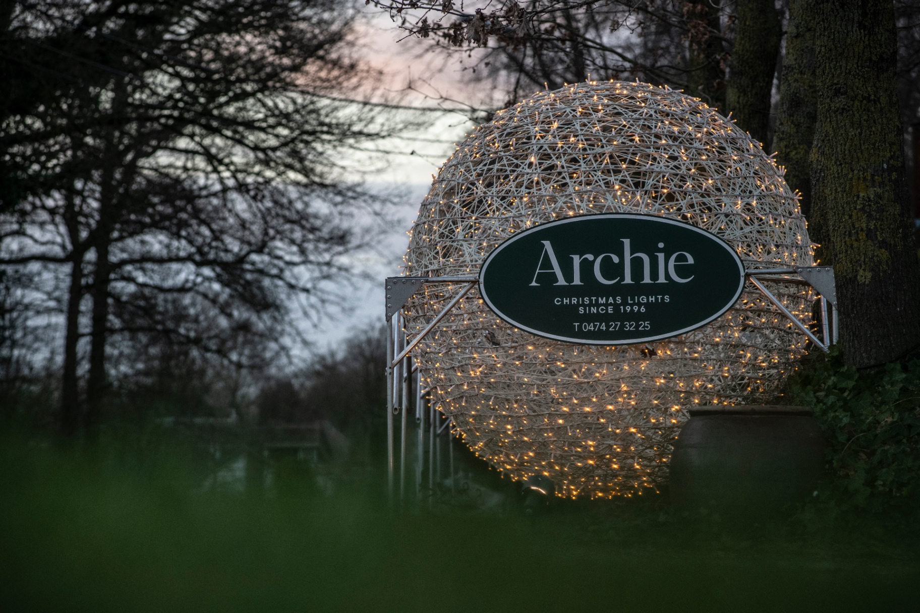 Grote Archie kerstbal met kenmerkend embleem bij schemer
