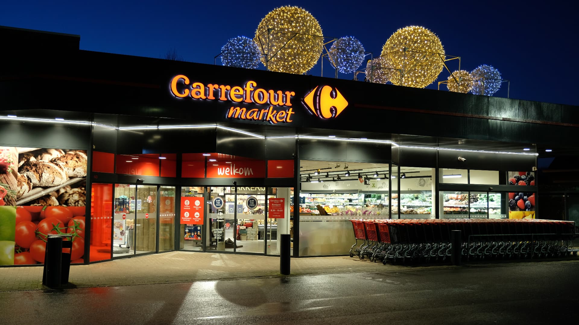 Grote kerstballen op het dak van een supermarkt